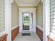 Covered front porch with brick accents and a storm door at 519 Garendon Dr, Cary, NC 27519