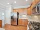 Modern kitchen with stainless steel appliances, wooden cabinets, and hardwood flooring at 519 Garendon Dr, Cary, NC 27519