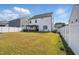 Large backyard featuring a white fence, well-kept lawn, and a charming pergola dining area at 521 Glenwyck Ct, Fuquay Varina, NC 27526