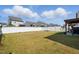 Well-maintained backyard with a white fence, showcasing a large grassy area and pergola at 521 Glenwyck Ct, Fuquay Varina, NC 27526
