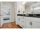 Beautiful bathroom with dual sinks, black granite countertops, white cabinets, and a view of the bedroom at 521 Glenwyck Ct, Fuquay Varina, NC 27526