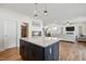 Open-concept kitchen boasts light countertops, white cabinets, large navy blue island, and view of dining and living area at 521 Glenwyck Ct, Fuquay Varina, NC 27526