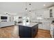 Open-concept kitchen boasts stainless appliances, white cabinets, light countertops, and a large navy blue island at 521 Glenwyck Ct, Fuquay Varina, NC 27526