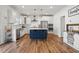 Open-concept kitchen boasts stainless appliances, white cabinets, subway tile backsplash, and a large navy blue island at 521 Glenwyck Ct, Fuquay Varina, NC 27526