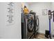 Laundry room with front loading washer and dryer, storage shelves, and decor with laundry related images at 521 Glenwyck Ct, Fuquay Varina, NC 27526