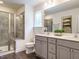 Contemporary bathroom features dual sinks, gray cabinets, a glass-enclosed shower, and modern fixtures at 555 Whitley Ridge Dr, Clayton, NC 27527