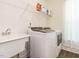 Well-lit laundry room boasts white washer/dryer set, sink and wire shelving for organizing cleaning products at 555 Whitley Ridge Dr, Clayton, NC 27527