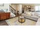 Open-concept living room with stairs, stylish rug, and gray sofa at 555 Whitley Ridge Dr, Clayton, NC 27527