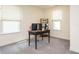 Bright home office boasts neutral walls, plush carpeting, a dark table and shelves, and windows for natural light at 555 Whitley Ridge Dr, Clayton, NC 27527
