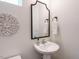 Elegant powder room with pedestal sink, decorative mirror, and artwork at 555 Whitley Ridge Dr, Clayton, NC 27527