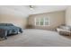 Spacious carpeted bedroom with a cozy sitting area, a bed, and a bright window view at 624 Meadowgrass Ln, Wake Forest, NC 27587