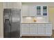 Stainless steel refrigerator adjacent to the white cabinetry and countertops in the kitchen at 624 Meadowgrass Ln, Wake Forest, NC 27587