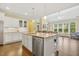 Open kitchen and living space with island, granite countertops, and stainless steel appliances at 624 Meadowgrass Ln, Wake Forest, NC 27587