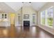 Living room with fireplace, lots of natural light, and hardwood floors next to kitchen at 624 Meadowgrass Ln, Wake Forest, NC 27587