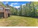 Expansive backyard features lush lawn and mature trees, offering plenty of space for recreation and outdoor activities at 7304 Hasentree Club Dr, Wake Forest, NC 27587