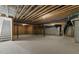 Unfinished basement with concrete floor, open ceiling with exposed beams, and stairs at 7304 Hasentree Club Dr, Wake Forest, NC 27587