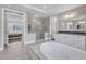 Open bathroom design showcasing a soaking tub, glass-enclosed shower, and dual vanities, perfect for relaxation at 7304 Hasentree Club Dr, Wake Forest, NC 27587