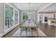 The dining room has a large window, hardwood floors and a long table with chairs at 7304 Hasentree Club Dr, Wake Forest, NC 27587