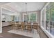The bright dining room has hardwood floors, large windows and a wooden table with 10 chairs at 7304 Hasentree Club Dr, Wake Forest, NC 27587