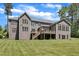 Rear exterior view of a home with a well-maintained lawn, a deck, and mature trees providing shade and privacy at 7304 Hasentree Club Dr, Wake Forest, NC 27587