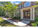 Elegant stone home showcasing a covered entryway with stately columns, double doors, and meticulously maintained landscaping at 7304 Hasentree Club Dr, Wake Forest, NC 27587