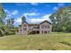 Rear exterior view of a home featuring a well-maintained lawn, a deck, and mature trees for shade and privacy at 7304 Hasentree Club Dr, Wake Forest, NC 27587