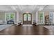 Grand foyer boasts dark hardwood floors, a tray ceiling, and a stylish chandelier, flanked by two sitting areas at 7304 Hasentree Club Dr, Wake Forest, NC 27587