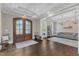 Bright foyer with dark hardwood floors, bench seating, and views into adjacent rooms with comfortable seating and decor at 7304 Hasentree Club Dr, Wake Forest, NC 27587