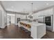 Bright kitchen with an oversized island, pendant lighting, stainless appliances, and eat-in barstool seating at 7304 Hasentree Club Dr, Wake Forest, NC 27587