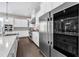 This kitchen has wooden floors, white cabinets and a stainless steel refrigerator at 7304 Hasentree Club Dr, Wake Forest, NC 27587