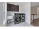 Bright laundry room featuring modern appliances, overhead cabinets, and convenient sink area at 7304 Hasentree Club Dr, Wake Forest, NC 27587