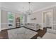 Bright living room featuring hardwood floors, neutral decor, a comfortable sofa, and views of the outdoors through large windows at 7304 Hasentree Club Dr, Wake Forest, NC 27587