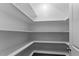 A walk in pantry with white shelves and an angled ceiling is shown at 7304 Hasentree Club Dr, Wake Forest, NC 27587