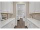 A butler's pantry with white cabinets, countertops, and hardwood floors is shown at 7304 Hasentree Club Dr, Wake Forest, NC 27587