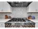 A professional grade gas stove with stainless steel hood and marble backsplash is shown at 7304 Hasentree Club Dr, Wake Forest, NC 27587