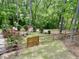 Lush backyard featuring a fence, manicured shrubs, and an inviting patio seating area at 7405 Chickadee Ct, Sanford, NC 27332