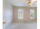 Neutral bedroom with two windows offering natural light and a ceiling fan at 7405 Chickadee Ct, Sanford, NC 27332