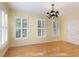 Open dining room featuring natural light, hardwood floors, and updated lighting fixture at 7405 Chickadee Ct, Sanford, NC 27332