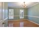 Dining room with hardwood floors, two large windows with plantation shutters and an elegant chandelier at 7405 Chickadee Ct, Sanford, NC 27332