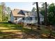 Back exterior of home showcasing the backyard with deck, fenced-in yard, and mature trees at 7405 Chickadee Ct, Sanford, NC 27332