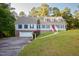 A two story traditional home featuring a two car garage, dormer windows, and manicured yard at 7405 Chickadee Ct, Sanford, NC 27332