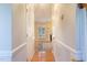Hallway view into the living room featuring hardwood floors and a fireplace at 7405 Chickadee Ct, Sanford, NC 27332