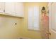 Bright laundry area featuring white cabinetry and shuttered window for natural light at 7405 Chickadee Ct, Sanford, NC 27332