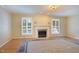 Spacious living room featuring hardwood floors, a fireplace, and plantation shutters at 7405 Chickadee Ct, Sanford, NC 27332