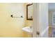 Powder room with a pedestal sink, mirror, towel rack, and yellow walls at 7405 Chickadee Ct, Sanford, NC 27332