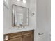 Powder room features a marble countertop and wood vanity with bronze fixtures and a stylish mirror at 801 N Elm St, Durham, NC 27701