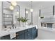 Bright bathroom showcasing double vanity with dark blue cabinets, stone counters, and modern pendant lighting at 801 N Elm St, Durham, NC 27701