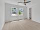 Bright bedroom with wood floors, two windows with backyard views, a modern ceiling fan, and closet at 801 N Elm St, Durham, NC 27701
