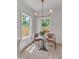 Sunlit breakfast nook with two chairs, a marble table, and views of the backyard through large windows at 801 N Elm St, Durham, NC 27701