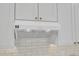 Close-up of kitchen hood over white backsplash and cabinets with gold hardware at 801 N Elm St, Durham, NC 27701